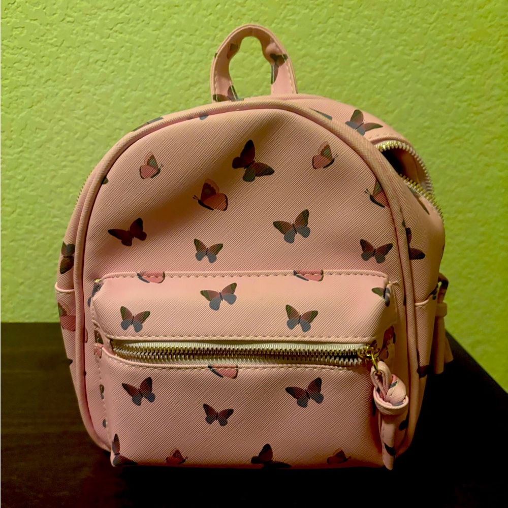 Cute pink mini backpack with butterfly design.